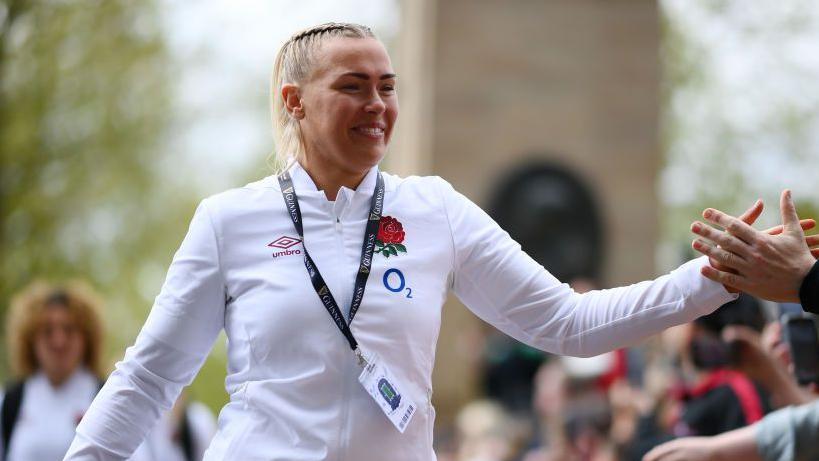 Rosie Galligan touching hands with a fan on the walk into a game