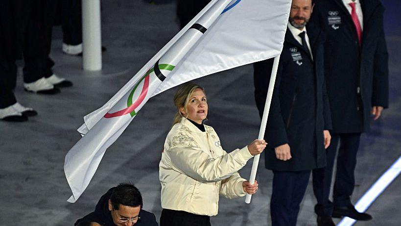 IOC president Kirsty Coventry hands over the Olympic flag