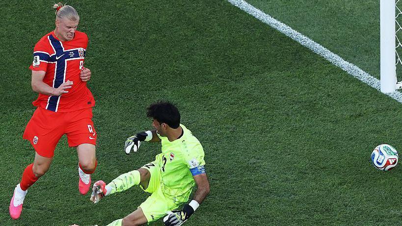 Norway forward Erling Haaland closes down Iraq goalkeeper Jalal Hassan, forcing a rushed clearance during a World Cup group-stage match