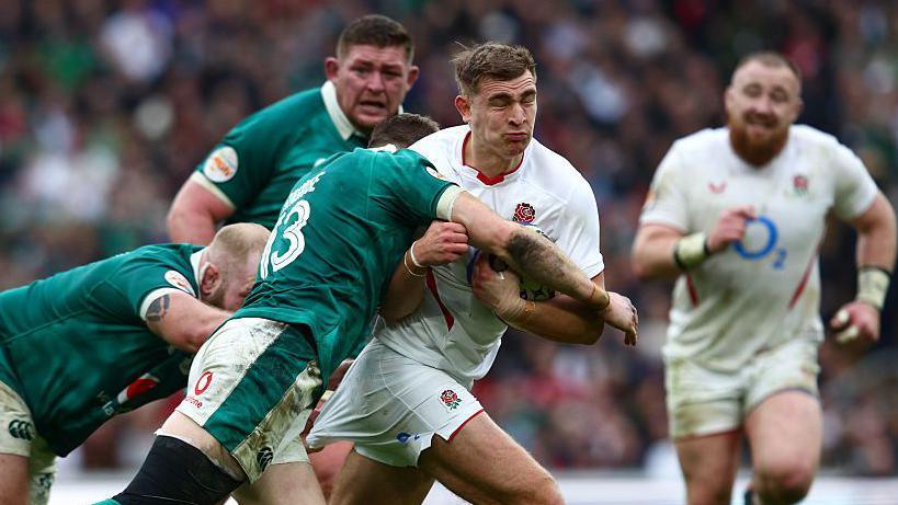 England scrum-half Jack van Poorvliet is tackled by Irish defenders during the Six Nations game at Twickenham on 21 February 2026