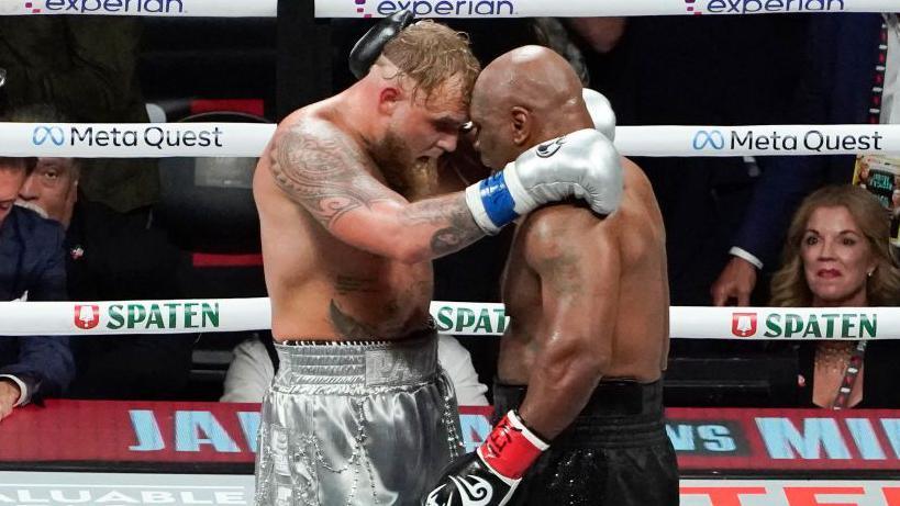 Jake Paul hugs Mike Tyson in the ring