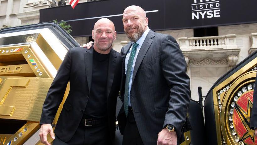 Paul Levesque puts his arm around the shoulder of Dana White as they pose for a picture