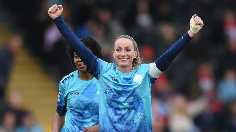 Kosovare Asllani with both arms raised in celebration