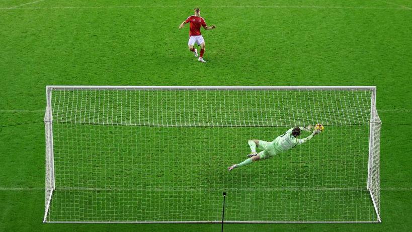 Wigan goalkeeper Tom Watson saves Kyle McAdam's penalty