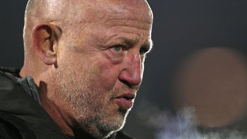 Steve Diamond watching Newcastle play on a cold January night, with his breath visible 