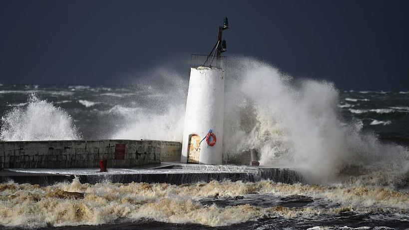 Big waves leap over a harbour wall in Girvan in south west Scotland