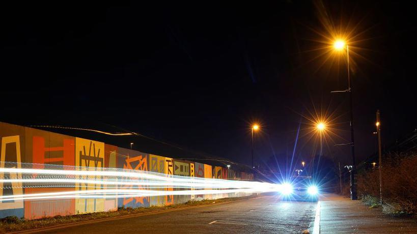 A street cruising car with its lights on