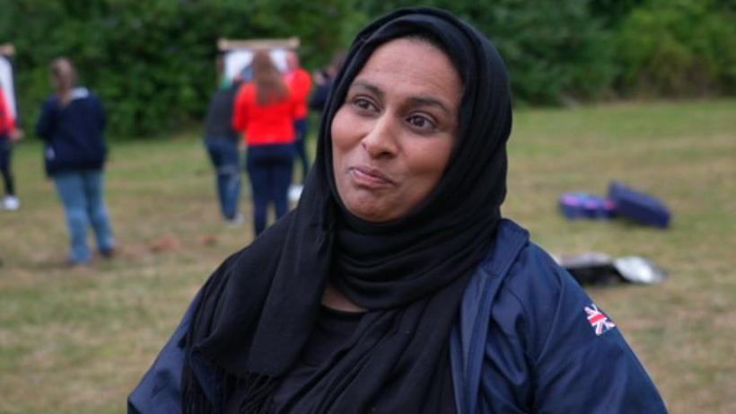 A woman in a hijab standing in a field