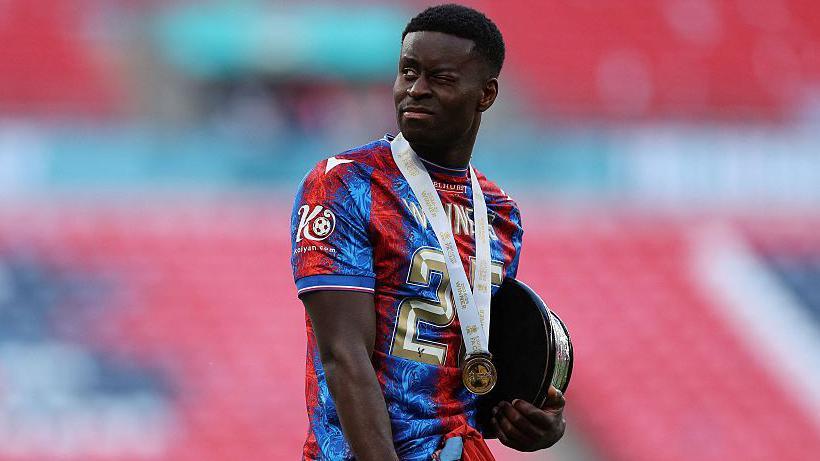 Marc Guehi holds the FA Cup base during the post-match celebrations after Crystal Palace beat Manchester City