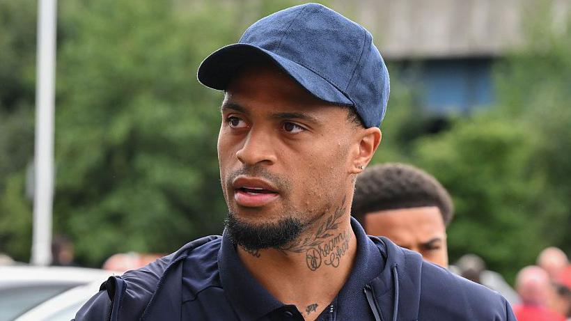 Middlesbrough striker Delano Burgzorg dressed in a blue baseball cap and blue polo shirt.