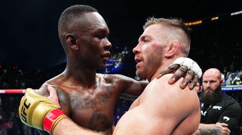 Israel Adesanya and Dricus de Plessis embrace after their fight at UFC 305