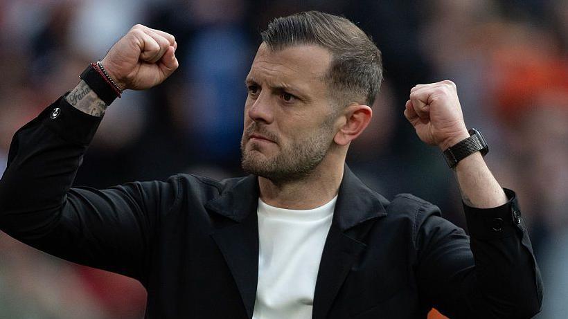 Jack Wilshere lifts his fists in celebration during a Luton Town match