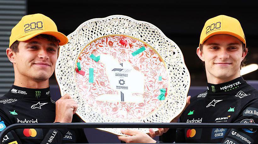 Lando Norris and Oscar Piastri holding the constructors' trophy