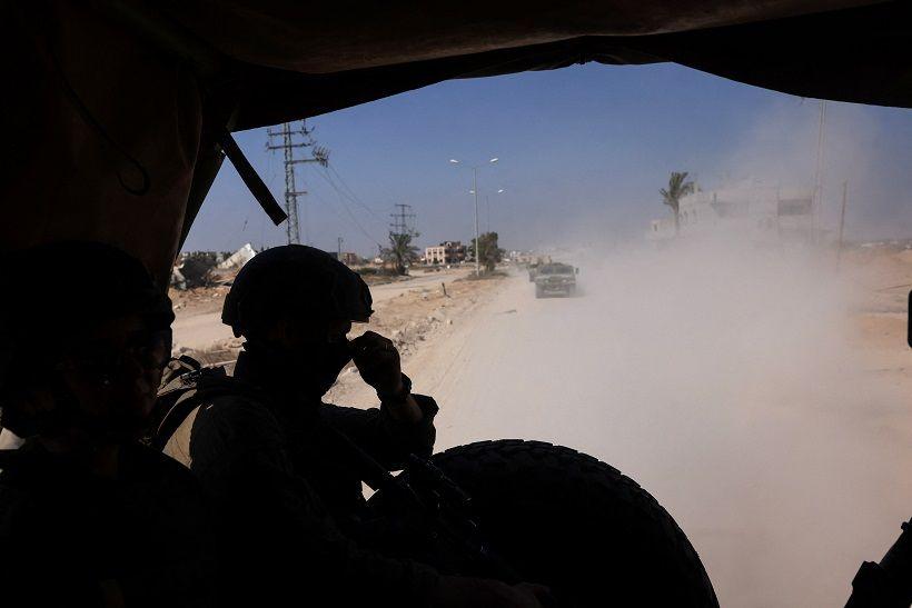 An Israeli soldier sits in a military vehicle as part of a convoy in a street in Gaza on 8 June, 2025.