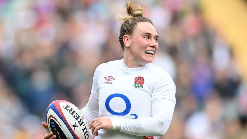 Megan Jones holds a rugby ball during a match 