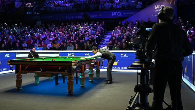 Ding Junhui plays a shot during the final of the 2023 UK Championship at the York Barbican