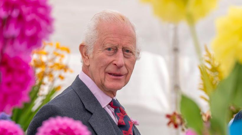 King Charles III surrounded by flowers