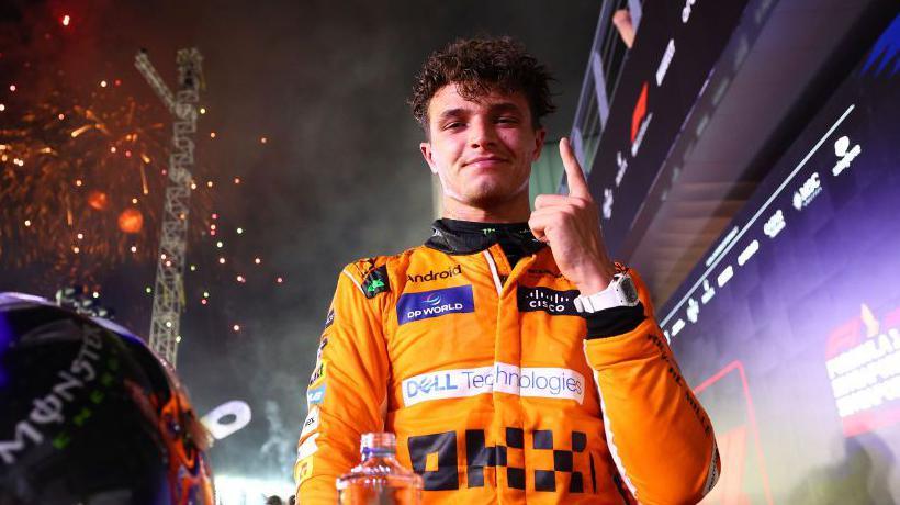 Lando Norris holds his left index finger up in celebration following the Singapore Grand Prix