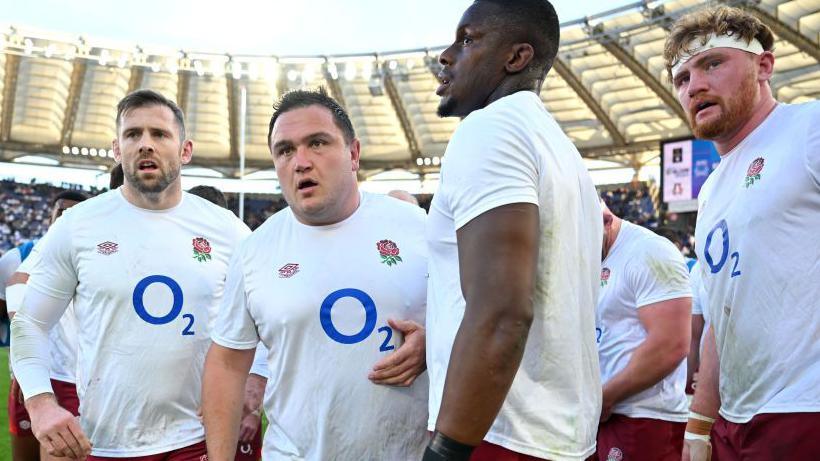 England players, included Jamie George and Maro Itoje, huddle at the Olympic Stadium in Italy