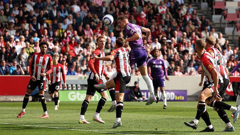 Tom Cairney scores a header for Fulham against Brentford in the Premier League