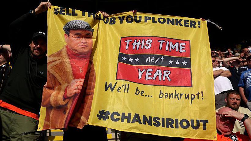 Sheffield Wednesday fans holding a banner protesting against club owner Dejphon Chansiri 