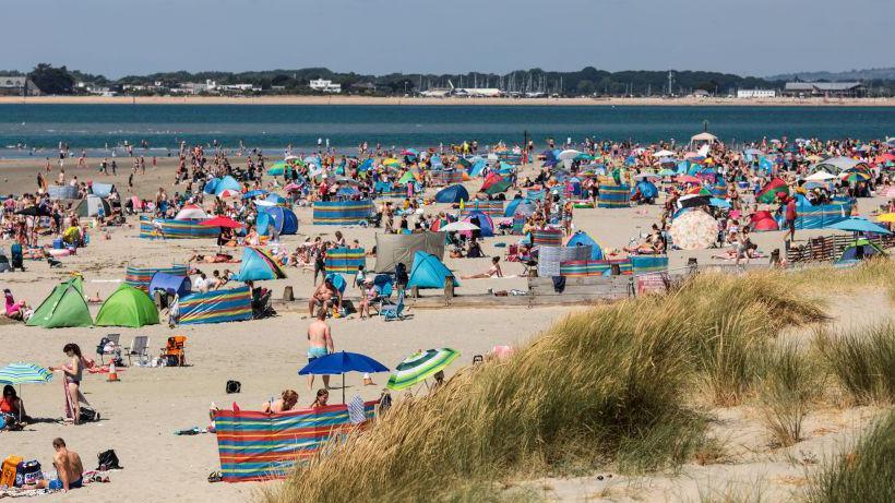 Beachgoers gather on West Wittering Beach in July 2018, when temperatures rose to 33.3 degrees celsius in some areas.