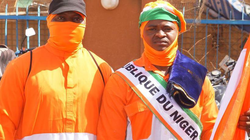 Citizens of Niger dressed in nationals perform Friday prayers and afterwards celebrate the departure of French troops in front of the French military base in the capital Niamey, Niger on 29 December 2023