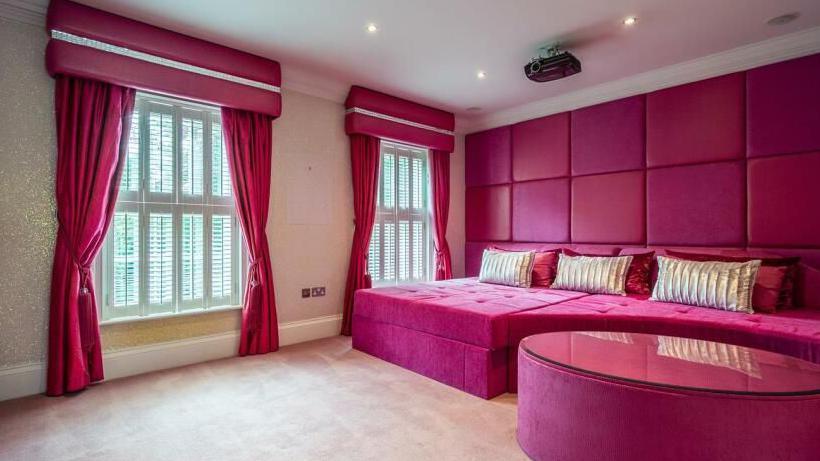 Cinema room at Klopp's mansion with pink decor and viewing sofa