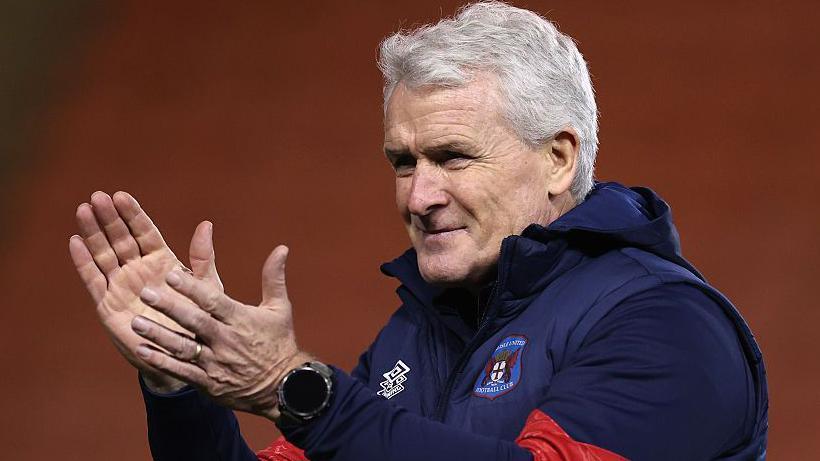 Mark Hughes applauds fans in the stands at the end of a match