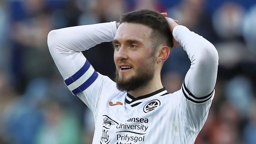 Matt Grimes in a Swansea shirt with hands on his head