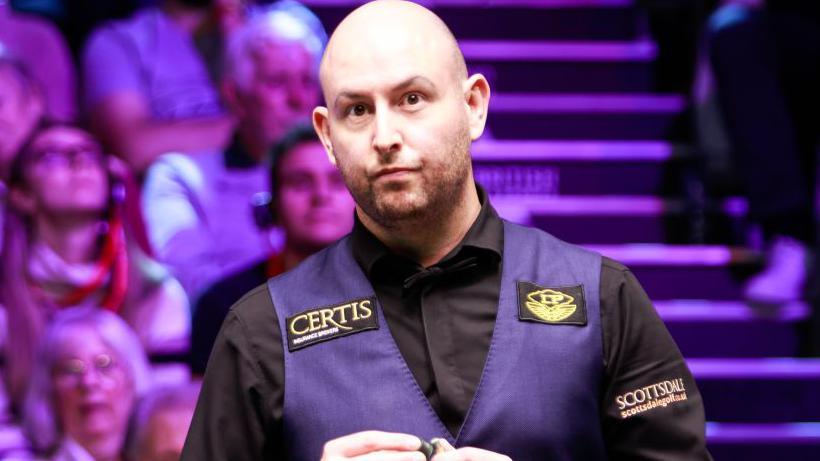 Matthew Selt chalking his cue during a match