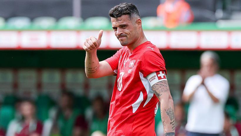 Granit Xhaka with a thumbs up in a Switzerland home kit