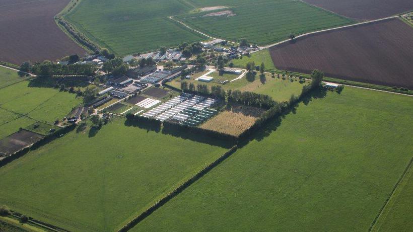 Aerial view of buildings at North Sea Camp surrounded by trees and farmland.