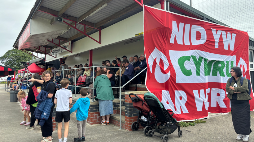 Rali Cymdeithas yr Iaith gyda baner 'Nid yw Cymru ar Werth'
