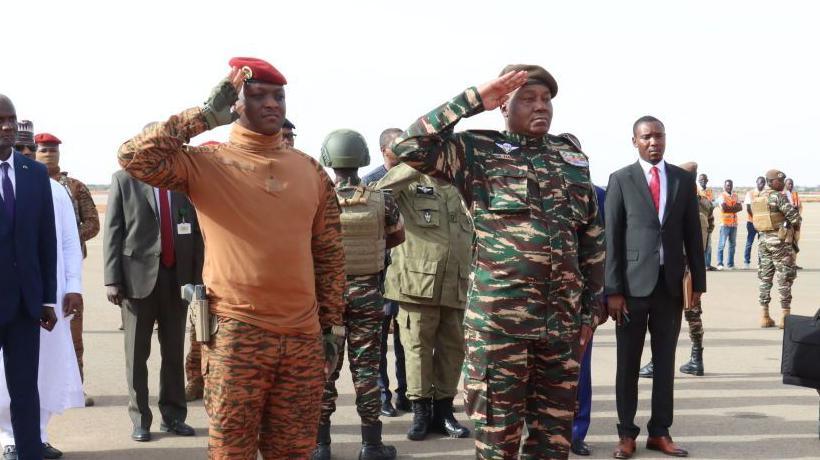 Two junta leaders, Niger's General Abdourahamane Tiani salutes next to his Burkinabe counterpart Captain Ibrahim Traoré