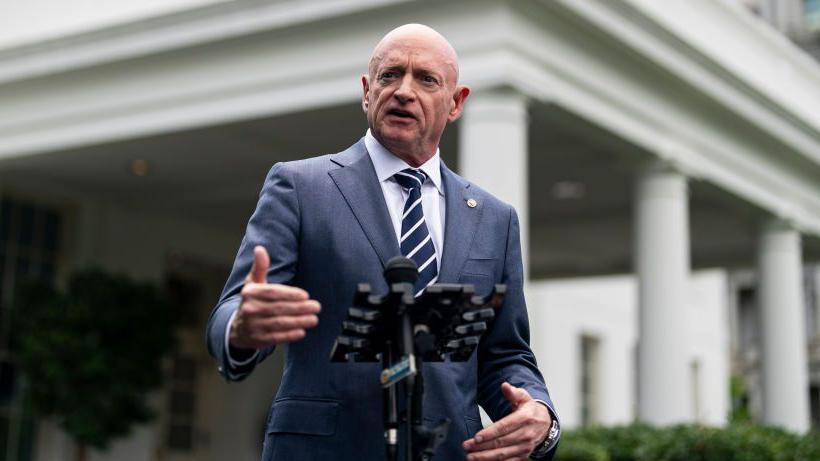 Kelly standing at podium in front of white house