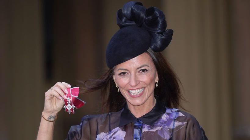 Davina McCall poses after being made an MBE, Member of the Order of the British Empire, during an investiture ceremony at Buckingham Palace on 31 January 2024