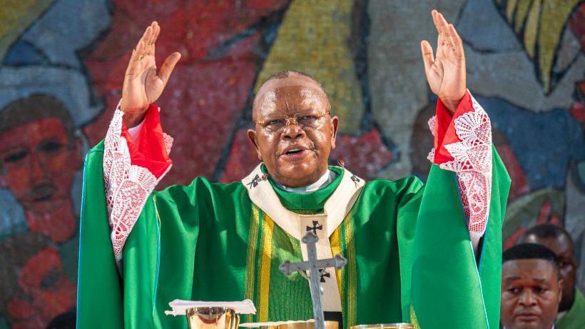 Cardinal Fridolin Ambongo wears a green religious attire as he stands at the pulpit in a church at Notre Dame du Congo Cathedral in the DR Congo capital Kinshasa - Sunday 9 February 2025