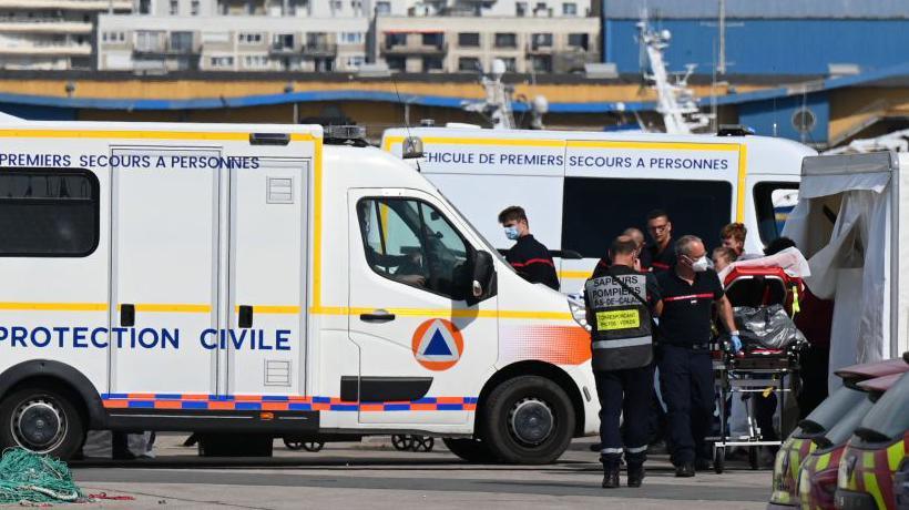 Firefighters provide assistance to an injured migrant after a vessel carrying dozens trying to cross the Channel 