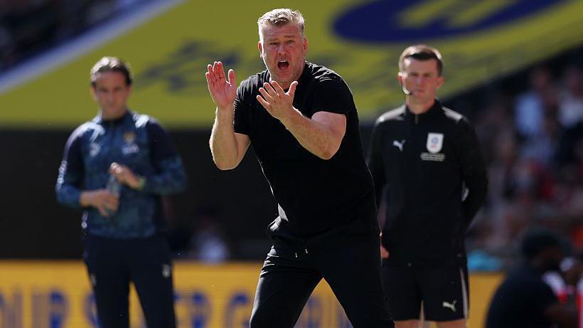 Karl Robinson shouts instructions to his Salford City players during the League Two play-off final