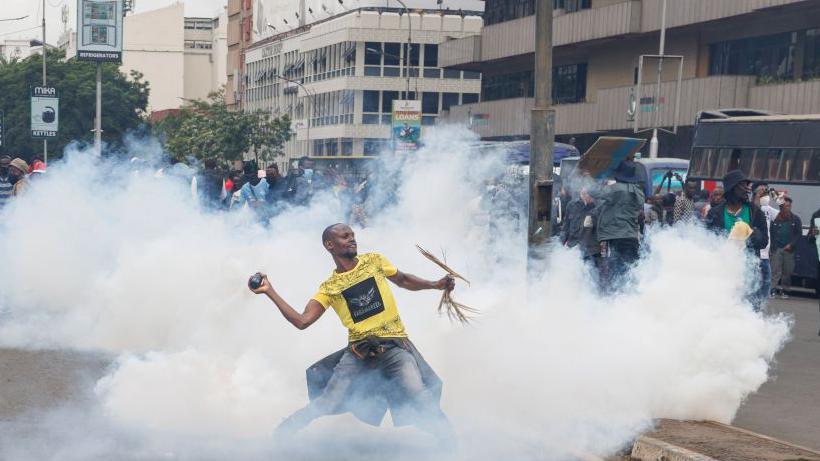 A protester throws back a tear gas canister at Kenyan anti-riot police officers during a demonstration against tax hikes as Members of the Parliament continue to debate the Finance Bill 2024 in downtown Nairobi on June 20, 2024.