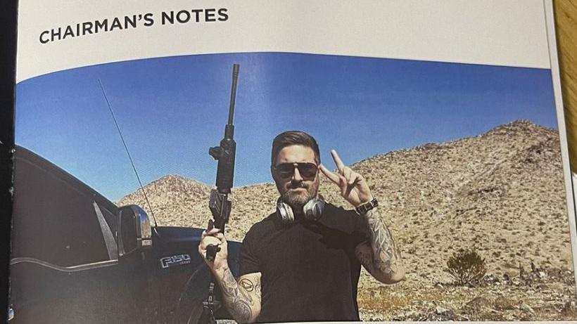 A photo of the matchday program with the headline "Chairman's Notes" and below that a photo of Peter McCormack holding a large black gun in his right hand and doing the V-peace sign with the other. He is standing with a scrubland behind and a black vehicle to his right.