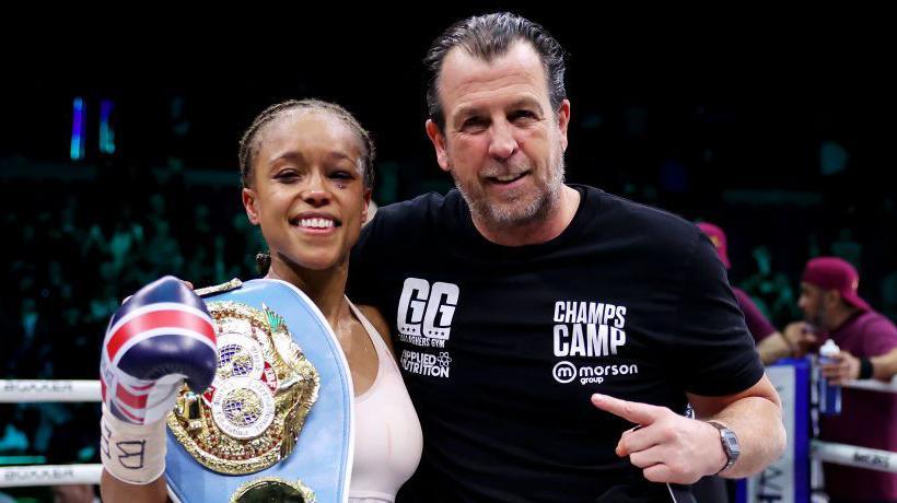 A bruised Natasha Jonas smiles beside her coach Joe Gallagher