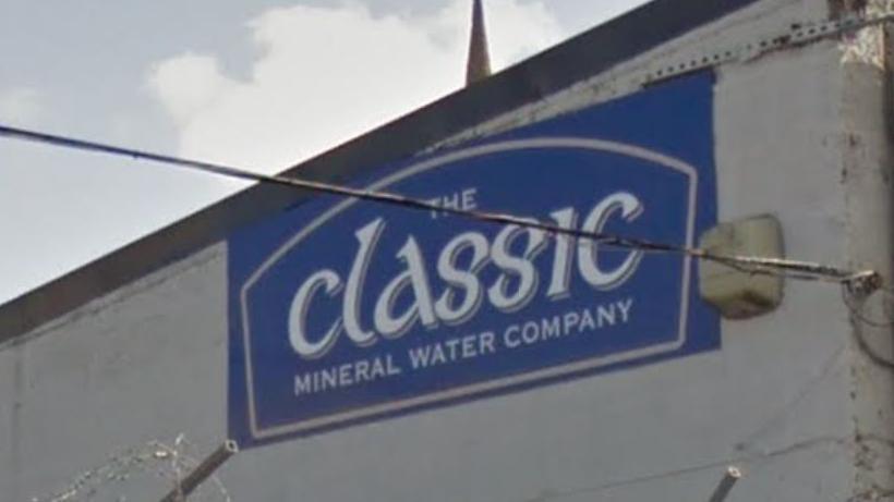 Sign showing The Classic Mineral Water Company, in white text on a blue background.