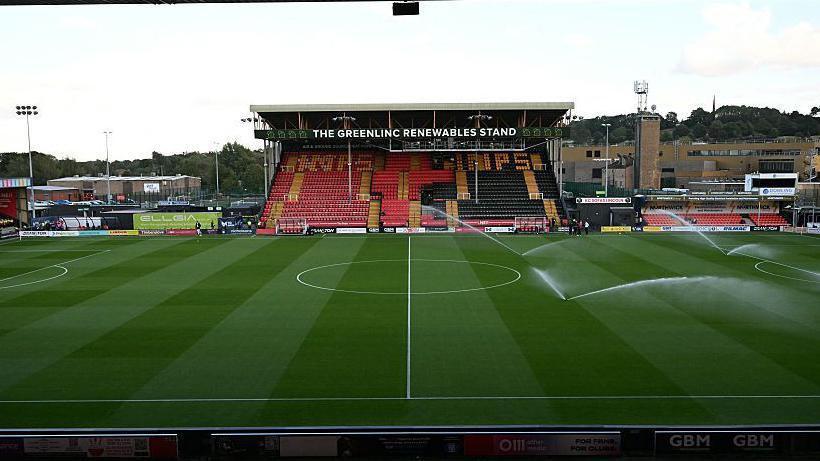 A general view of Lincoln City's Sincil Bank stadium from the stands on the halfway line with sprinklers going off to water the pitch in the right-hand half of the pitch