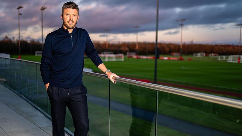 Michael Carrick standing on a balcony overlooking Manchester United's Carrington training ground