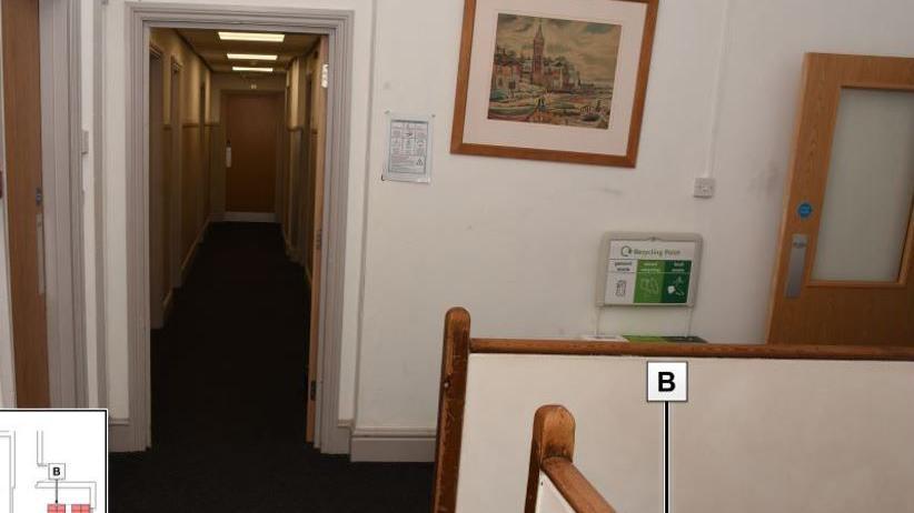 A corridor in the sleeping quarters of Blundell's School in Tiverton with doors on either side and dark carpet on the floor.