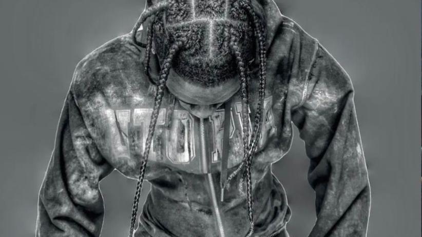 A black and white photo of Travis Scott  wearing one of Timothy Gibbons corset hoodies