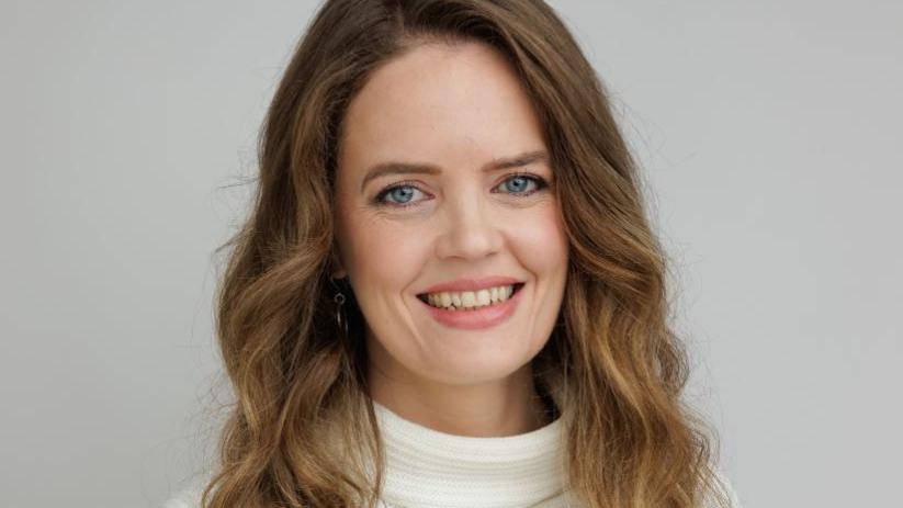 Trása Canavan, with long brown hair, wearing white jumper.