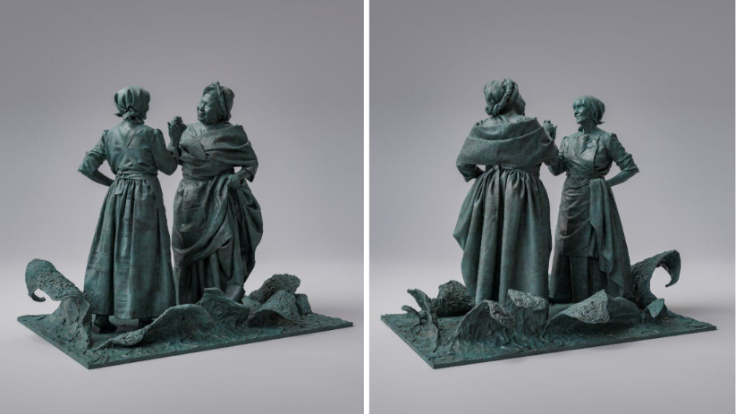 A bronze statue which depicts an enslaved black woman clasping hands with a white mill worker